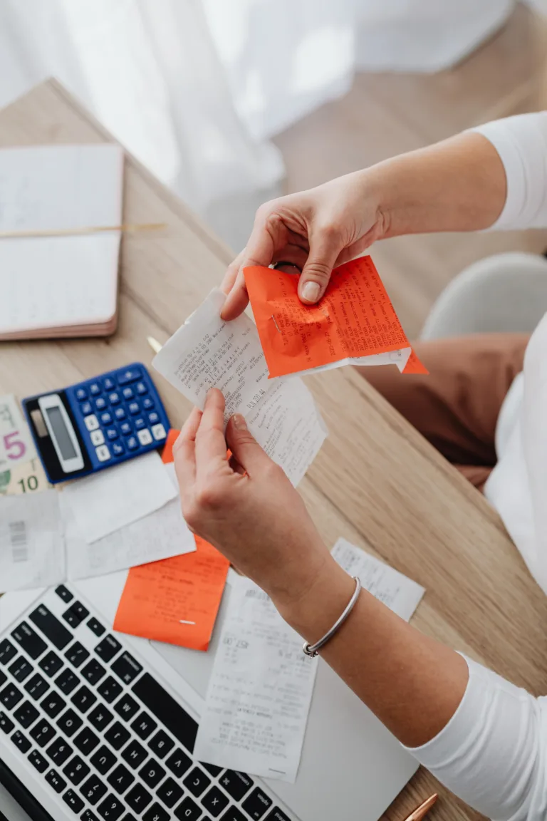 Bookkeeper organizing receipts and calculating expenses for a Slough business